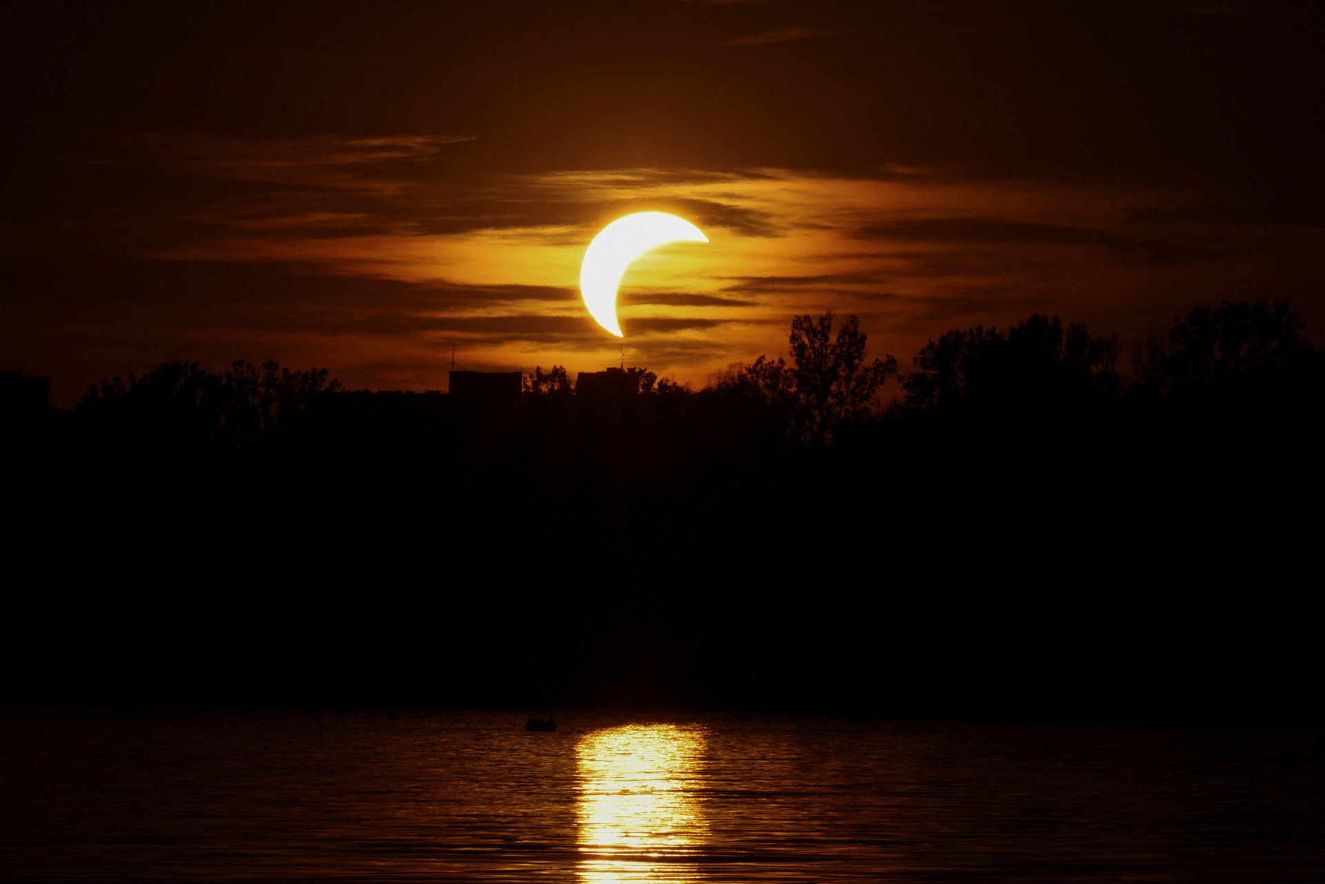 Un eclipse solar parcial al atardecer sobre el río Vístula, visto desde la orilla en Varsovia, Polonia. Foto: Reuters